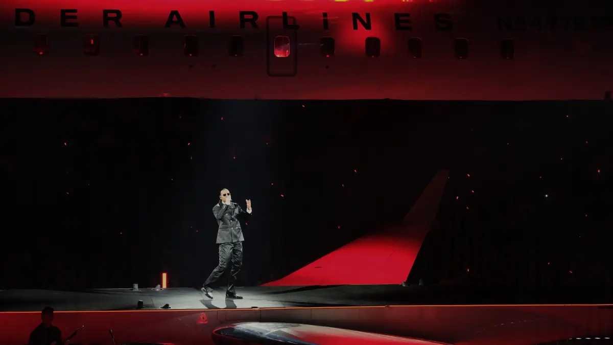 Apache liefert in Berlin eine große Show: Anstatt auf einer klassischen Bühne, performt der Rapper und Sänger lieber in einem echten Flugzeug. Ausgehöhlt und zweigeteilt steht es mitten in der Uber Arena.