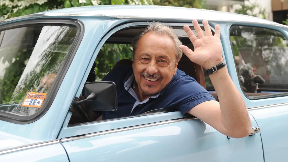 Wolfgang Stumph: ARCHIV - 09.06.2015, Bayern, München: Der Schauspieler Wolfgang Stumph sitzt am 10.06.2015 in München (Bayern) bei einem Fototermin bei Dreharbeiten zur TV-Dokumentation "Go Trabbi Go Forever" winkend in einem Trabbi. (zu dpa: «Volksschauspieler und Brückenbauer: Wolfgang Stumph wird 80») Foto: Tobias Hase +++ dpa-Bildfunk +++