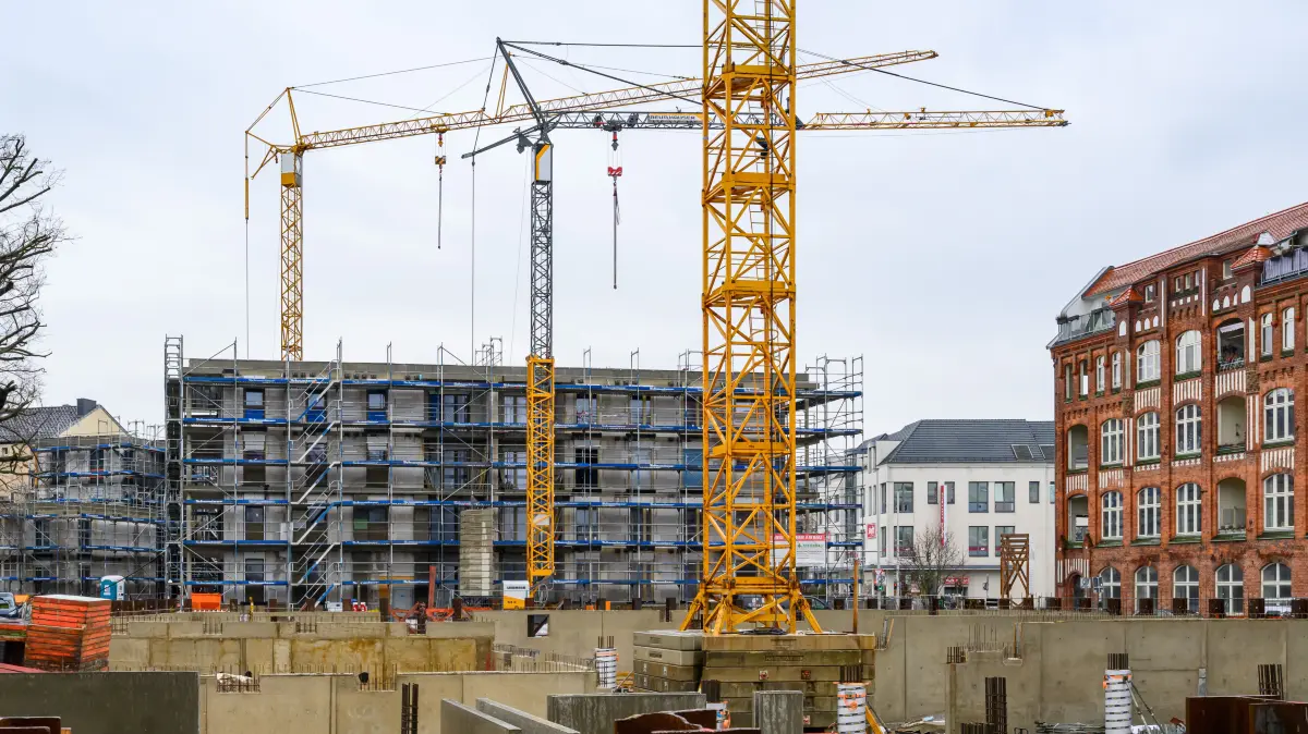 Auf einer Baustelle für sozialen Wohnungsbau stehen mehrere Baukräne und Rohbauten. Im Vordergrund sind Schalungen und Betonwände eines im Bau befindlichen Gebäudes zu sehen. In zentraler Lage der Innenstadt errichtet die Gebäudewirtschaft Cottbus GmbH (GWC) in mehreren Bauabschnitten 130 neue Wohnungen. Am 15. Januar 2026 stellt das Pestel-Institut in Berlin den «Sozialen Wohn-Monitor 2026» vor. Die Studie liefert aktuelle Zahlen zum Wohnungsdefizit in Deutschland und den Bundesländern und thematisiert Diskriminierungen auf dem Wohnungsmarkt. +++ dpa-Bildfunk +++