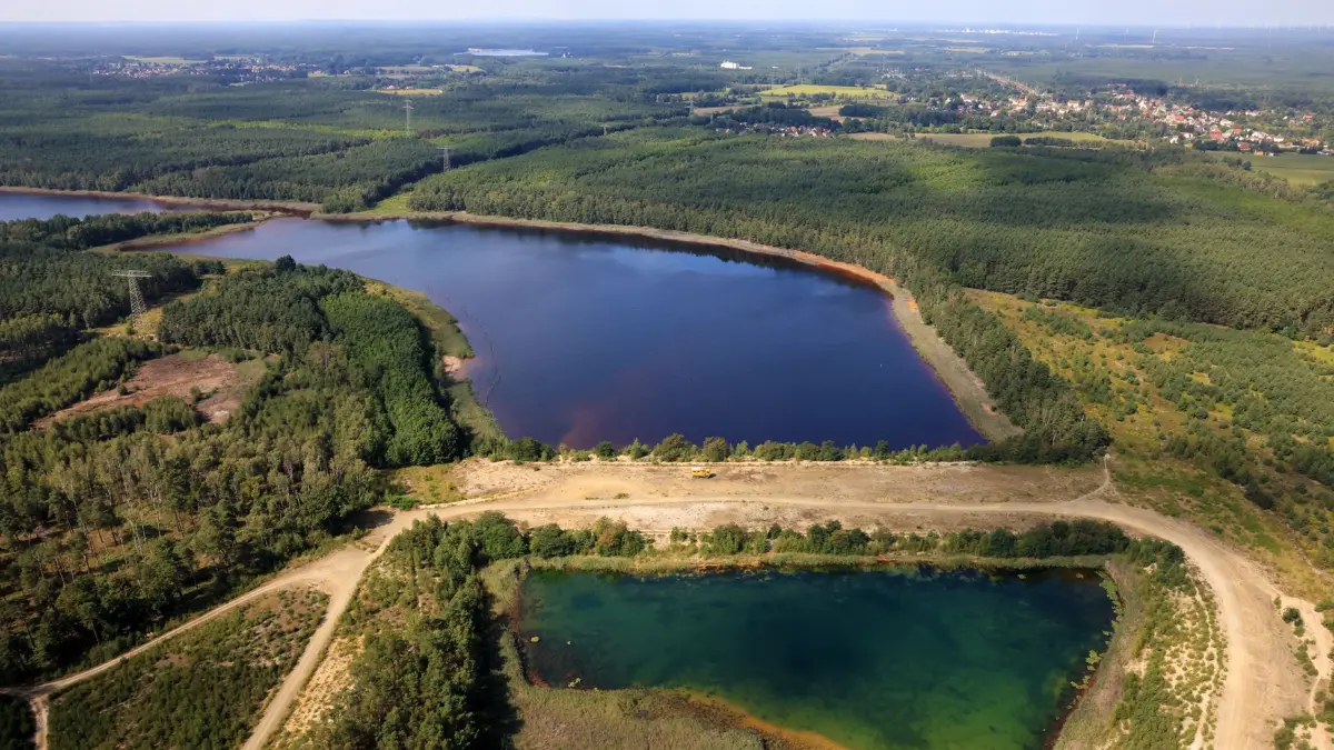 Blick auf das Restloch Heide VI. Zu sehen ist in der Bildmitte der stabilisierte Trenndamm zum benachbarten Restloch Heide V. Darüber hinaus präsentiert sich der ehemalige Verbindungsdamm zwischen Johannisthal und Hosena im Bild links oben.