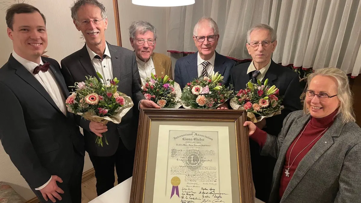Die Lions-Gründungsmitglieder Egon Schaeuble, Klaus Schmidtchen, Dr. Konrad Beyer und Ulrich Angermann (v.l.) erhalten einen Blumenstrauß als Dankeschön von Lions-Präsidentin Andrea Lenartowsky (r.) und dem Präsidenten des Hilfswerkes, Matthias Böhm (l.). Im Vordergrund die Gründungsurkunde aus dem Jahr 1996.