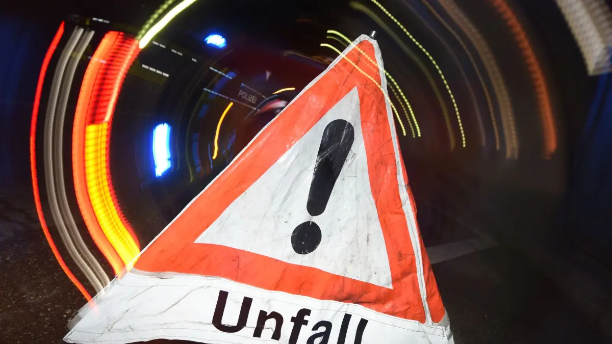 Autounfall - Symbolbild: ARCHIV - 21.06.2015, Baden-Württemberg, Freiburg: ARCHIV - ILLUSTRATION - Ein Warndreieck mit dem Schriftzug «Unfall» steht vor einem Blaulicht auf der Straße. (zu dpa: «Autofahrer stirbt nach Unfall in Chemnitz») Foto: Patrick Seeger/dpa +++ dpa-Bildfunk +++