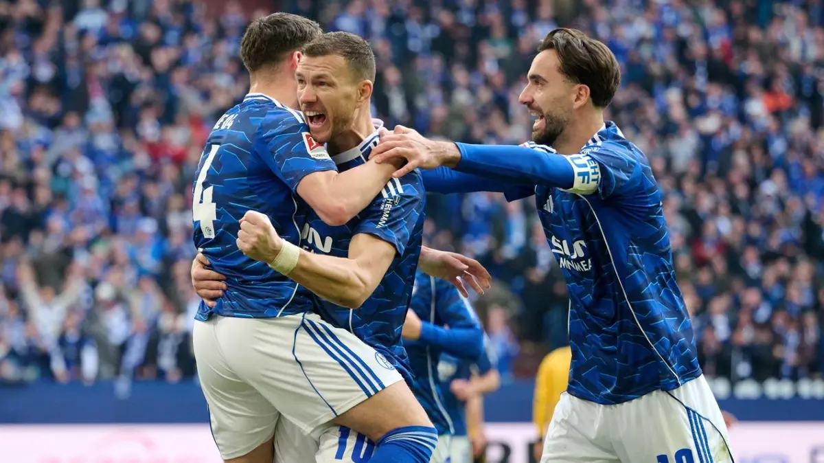 FC Schalke 04 - Dynamo Dresden: 07.02.2026, Nordrhein-Westfalen, Gelsenkirchen: Fußball: 2. Bundesliga, FC Schalke 04 - Dynamo Dresden, 21. Spieltag, Veltins Arena. Edin Dzeko (FC Schalke 04, M) jubelt mit Hasan Kuruçay (FC Schalke 04) und Kenan Karaman (FC Schalke 04, r) über seinen Treffer zum 1:0. Foto: Bernd Thissen/dpa - WICHTIGER HINWEIS: Gemäß den Vorgaben der DFL Deutsche Fußball Liga bzw. des DFB Deutscher Fußball-Bund ist es untersagt, in dem Stadion und/oder vom Spiel angefertigte Fotoaufnahmen in Form von Sequenzbildern und/oder videoähnlichen Fotostrecken zu verwerten bzw. verwerten zu lassen. +++ dpa-Bildfunk +++