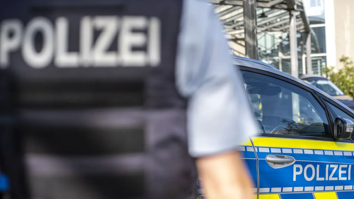 ILLUSTRATION - 28.09.2021, Nordrhein-Westfalen, Gütersloh: Ein Polizist steht vor einem Streifenwagen. Ermittler der Kriminalpolizei in Köln haben bei der Wohnungsdurchsuchung eines unter Verdacht geratenen Altenpflegers mutmaßliches wertvolles Diebesgut entdeckt. (zu dpa: «Senioren im Heim bestohlen - Diebesgut bei Pfleger entdeckt») Foto: David Inderlied/dpa +++ dpa-Bildfunk +++