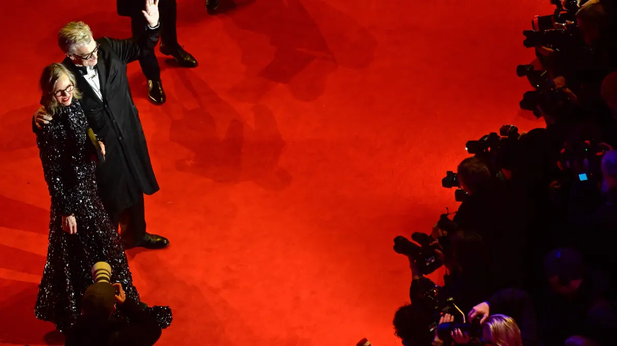 776458798: German film director Wim Wenders and his wife Donata Wenders wave as they arrive on the red carpet for the premiere of the film "No Good Men" presented in the Berlinale Special Gala section and opening the 76th Berlinale, Europe's first major film festival of the year, in Berlin on February 12, 2026. (Photo by John MACDOUGALL / AFP)