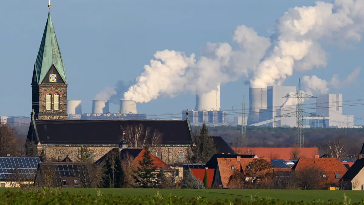 Kraftwerk Boxberg: ILLUSTRATION - 08.12.2025, Sachsen, Radibor: Das Kraftwerk Boxberg, betrieben von der Lausitz Energie Kraftwerke AG (LEAG), ist hinter dem Ort Radibor mit der Kirche Maria Rosenkranzkönigin im Landkreis Bautzen zu sehen. (zu dpa: «Sorgen um den Strukturwandel in der Oberlausitz») Foto: Robert Michael/dpa +++ dpa-Bildfunk +++