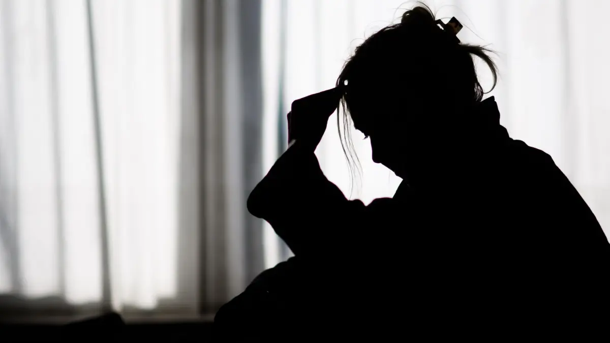 Depression bei jungen Erwachsenen: ARCHIV - 19.02.2025, Niedersachsen, Hannover: Die Silhouette einer Frau zeichnet sich vor einer hellen Fensterfront ab (gestellte Szene). (zu dpa: «Chinas sorgenvolle Jugend sucht Rat bei KI») Foto: Julian Stratenschulte/dpa +++ dpa-Bildfunk +++