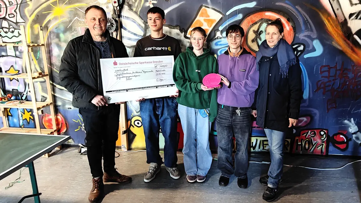 Das Postkosmos ist mit dem Jugendengagementpreis 2025 geehrt worden. Bürgermeister Mirko Pink (v. l.), Ryszard Szczepanski, Henriette Meixner und Franz Bleck vom Jugendzentrum sowie Bernadette Zeller vom Kinder- und Jugendnetzwerk aus Bischofswerda freuen sich über den symbolischen Scheck.