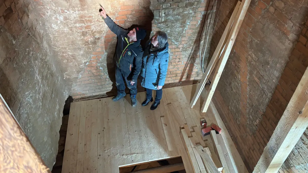 Silke Hauptvogel, Vorsitzende des Gemeindekirchenrates, und Heiko Lehmann von der Zimmerei Thielke aus Zöllmersdorf, im Turm der Stadtkirche St. Catharina in Elsterwerda. Dort mussten zahlreiche morsche Balken ausgetauscht werden.