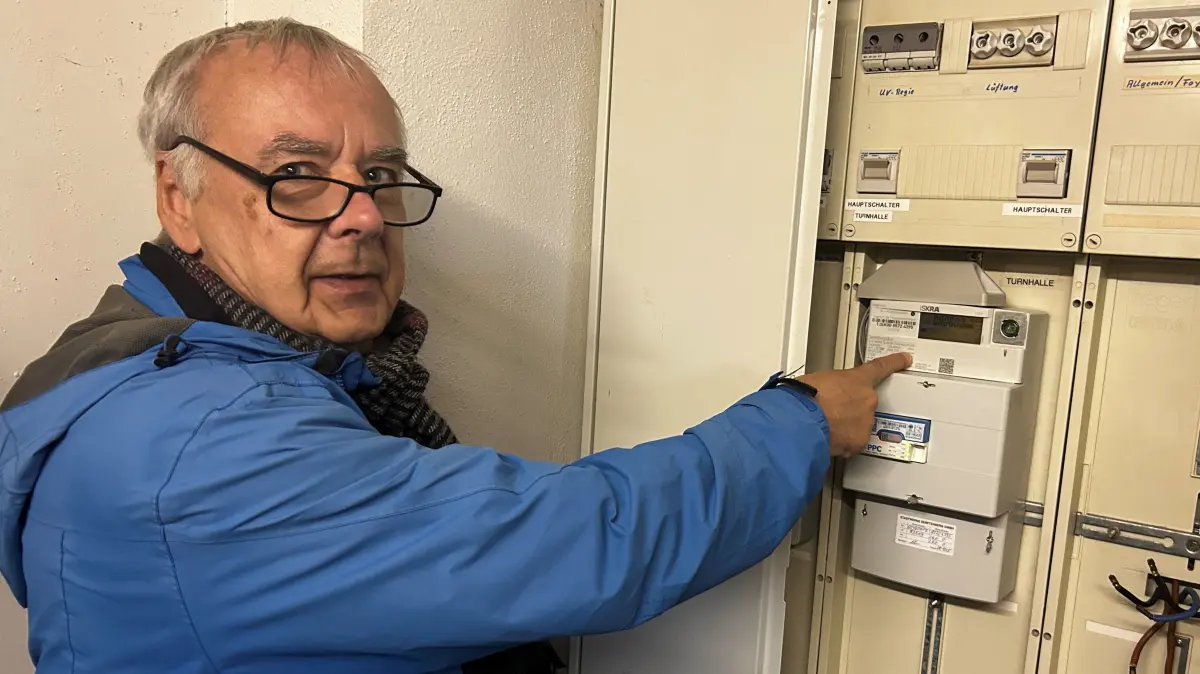 Volkmar Köster zeigt auf den Zähler in der Seesporthalle Großkoschen, für dessen Betrieb er jetzt 6 Cent entrichten muss.