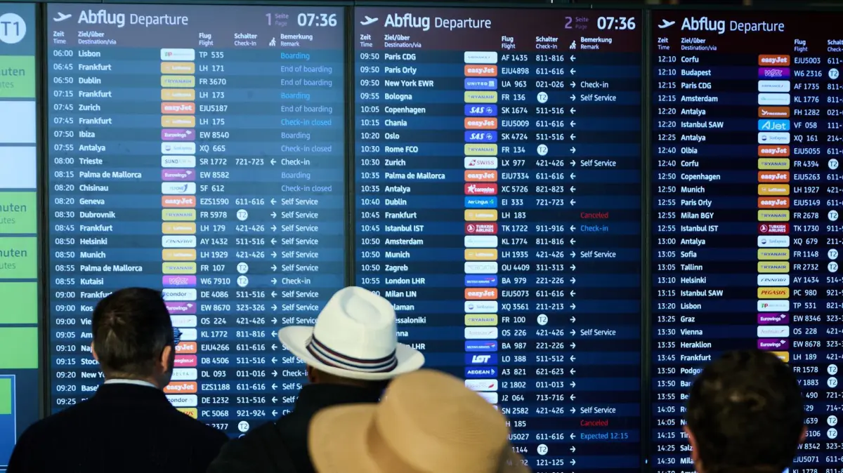 Nach dem Cyberangriff auf Flughäfen - BER: ARCHIV - 28.09.2025, Brandenburg, Schönefeld: Menschen stehen am Flughafen BER und schauen auf die Abflugtafel. (zu dpa: «Regierung hat intern noch Redebedarf zu Cyberpakt mit Israel») Foto: Annette Riedl/dpa +++ dpa-Bildfunk +++