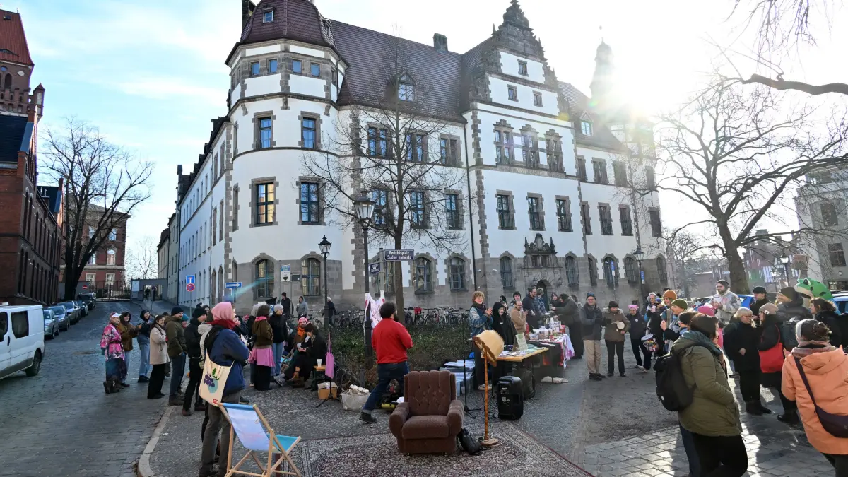 Protest K29 Gerichtsplatz : K29-Projekt kämpft ums Überleben
Eine bunte Kundgebung mit Bewohnern und Sympathisanten auf dem Gerichtsplatz vor dem Landgericht in Cottbus begleitete am Donnerstagvormittag den Gerichtsprozess um das alternative Wohnprojekt Karlstraße 29. Für die Bewohnerinnen und Bewohner der K29, des Wohn- und Kulturprojektes in der Karlstraße 29, begann das neue Jahr mit einem weiteren Gerichtsprozess. Nach dem Scheitern der vorangegangenen juristischen Auseinandersetzungen und inzwischen erfolgter Modernisierung versucht der Berliner Eigentümer nun über einen weiteren Prozess seine Pläne mit einer Räumungsklage durchzusetzen. Die Bewohnerinnen und Bewohner des Hauses würden dagegen das Haus gern über ein Miethäusersyndikat kaufen, das hieße, dass das Haus denjenigen Mietern gehört, die darin wohnen, erklärte Mitbewohnerin und Mitorganisatorin der Kundgebung vor dem Landgericht, Mathilda Knorpp. Bisher sei der Eigentümer jedoch nicht zu Gesprächen bereit gewesen, obwohl man auf ihn zugegangen sei. Sollte es weiterhin keine außergerichtliche Einigung geben, würde das eine Veränderung der Struktur des Hauses und das Ende des bunten Projektes bedeuten. Im schlimmsten Falle stünden 12 Erwachsene, zwei Teenager, eine Katze und ein Hund in naher Zukunft auf der Straße. Für die Stadt würde das zugleich den Verlust eines wichtigen Kulturortes der ohnehin kleinen alternativen Szene in Cottbus bedeuten.