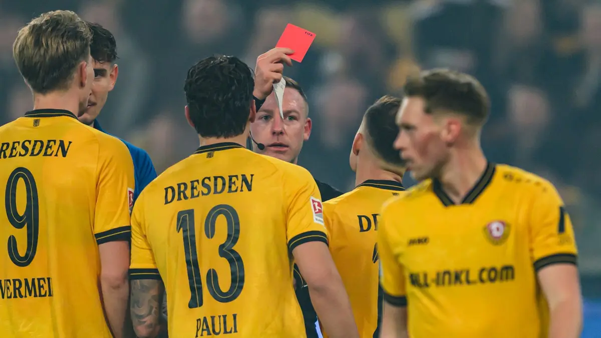 SG Dynamo Dresden - SV Darmstadt 98: 27.02.2026, Sachsen, Dresden: Fußball: 2. Bundesliga, SG Dynamo Dresden - SV Darmstadt 98, 24. Spieltag, Rudolf-Harbig-Stadion, Schiedsrichter Lars Erbst zeigt Jakob Lemmer (Dynamo Dresden, 2.v.r) die Gelb-Rote Karte. Foto: Robert Michael/dpa - WICHTIGER HINWEIS: Gemäß den Vorgaben der DFL Deutsche Fußball Liga bzw. des DFB Deutscher Fußball-Bund ist es untersagt, in dem Stadion und/oder vom Spiel angefertigte Fotoaufnahmen in Form von Sequenzbildern und/oder videoähnlichen Fotostrecken zu verwerten bzw. verwerten zu lassen. +++ dpa-Bildfunk +++