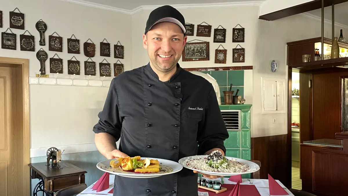 Raimung Stuckatz hält am 25.02.2026 im Gasthaus Stuckatz in Dollenchen einen Teller mit Salat und einen Teller mit Carpaccio in die Kamera.