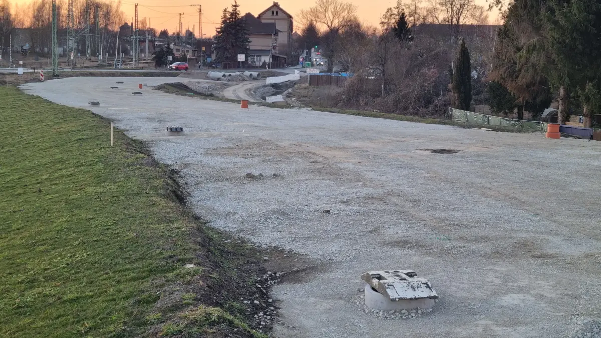 Ein Straßendamm mit leichtem Gefälle verbindet die im Bau befindliche Brücke über die Bahnstrecke Lübbenau–Cottbus mit der Bahnhofstraße (im Hintergrund).