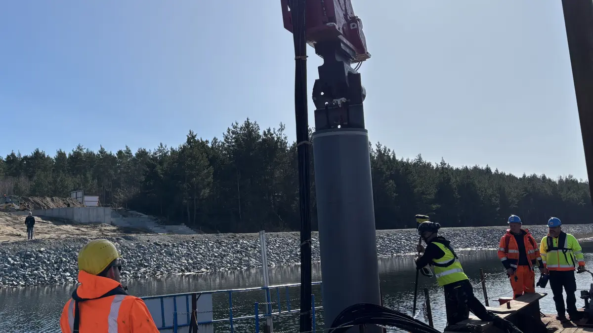 Hier bringen die Arbeiter der Firma Metzner unweit der Einfahrt vom Sedlitzer See in den Sornoer Kanal eine insgesamt 15 Meter lange Dalbe in den Seeboden ein.