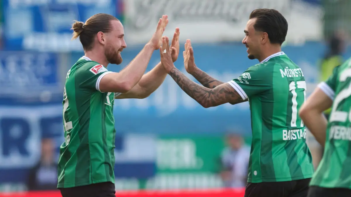 Preußen Münster - Hertha BSC: 08.03.2026, Nordrhein-Westfalen, Münster: Fußball, Männer: 2. Bundesliga, Preußen Münster - Hertha BSC, 25. Spieltag, Preußenstadion. Jannis Heuer (Preußen Münster, l) jubelt mit Oliver Batista-Meier (Preußen Münster) über sein Tor zum 1:1. Foto: Bernd Thissen/dpa - WICHTIGER HINWEIS: Gemäß den Vorgaben der DFL Deutsche Fußball Liga bzw. des DFB Deutscher Fußball-Bund ist es untersagt, in dem Stadion und/oder vom Spiel angefertigte Fotoaufnahmen in Form von Sequenzbildern und/oder videoähnlichen Fotostrecken zu verwerten bzw. verwerten zu lassen. +++ dpa-Bildfunk +++