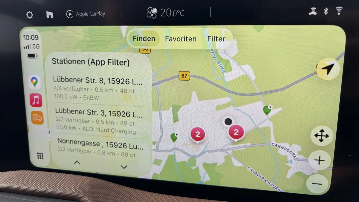 Bordbildschirm im E-Auto zeigt Lademöglichkeiten an.