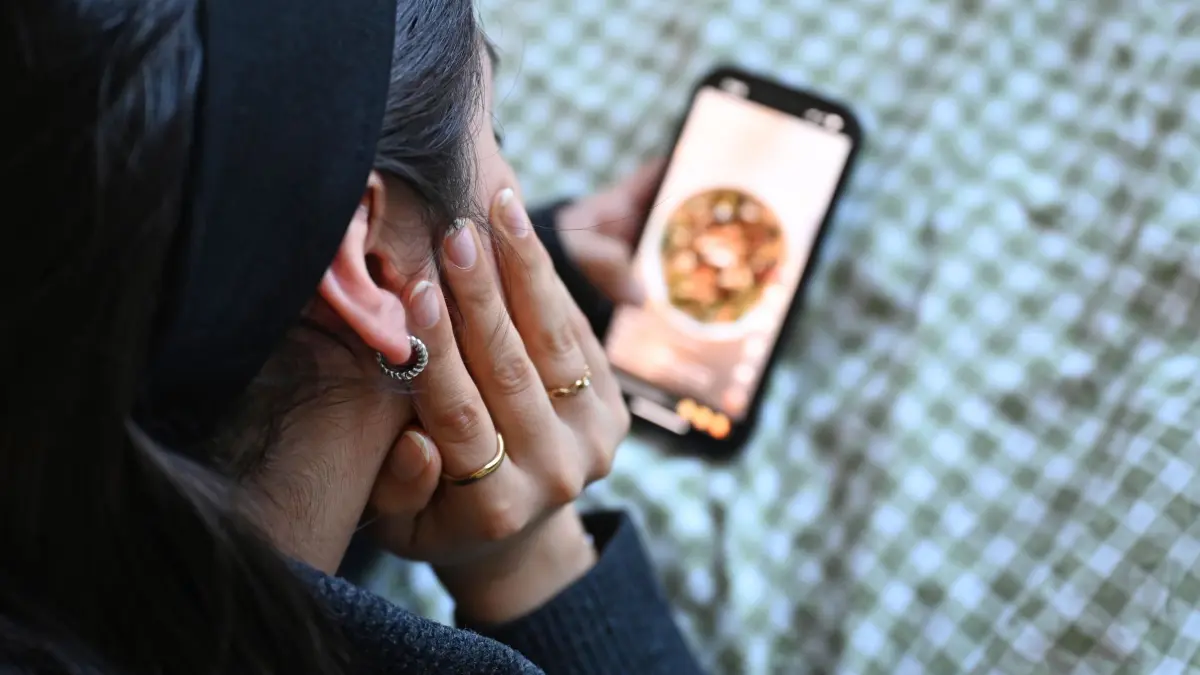 Jugendliche mit Smartphone: ILLUSTRATION - 19.01.2026, Berlin: Eine Jugendliche liegt mit dem Smartphone in der Hand auf dem Bett und scrollt durch die Social-Media-Plattform Tiktok. (zu dpa: «Britisches Unterhaus gegen Social-Media-Aus für Kinder») Foto: Elisa Schu/dpa +++ dpa-Bildfunk +++