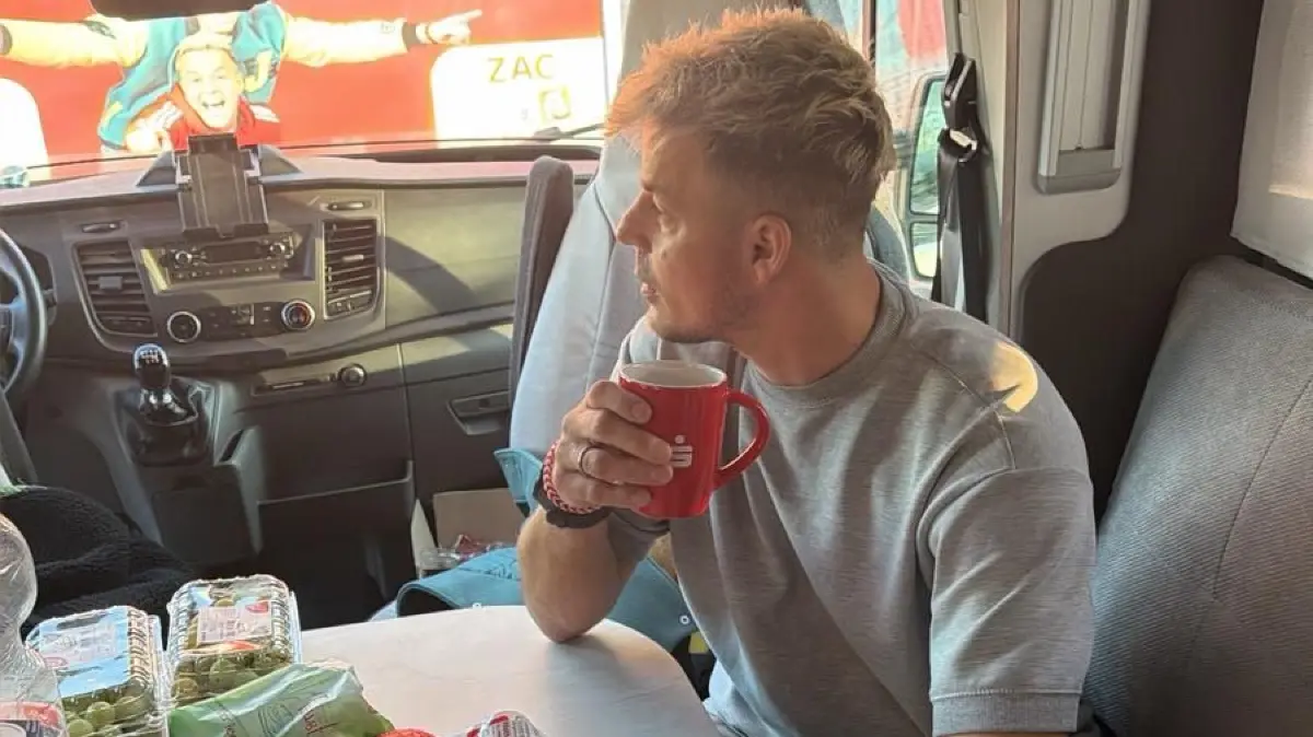 Behind the scenes im Wohnwagen: Alexander Knappe entspannt bei einem Heißgetränk.