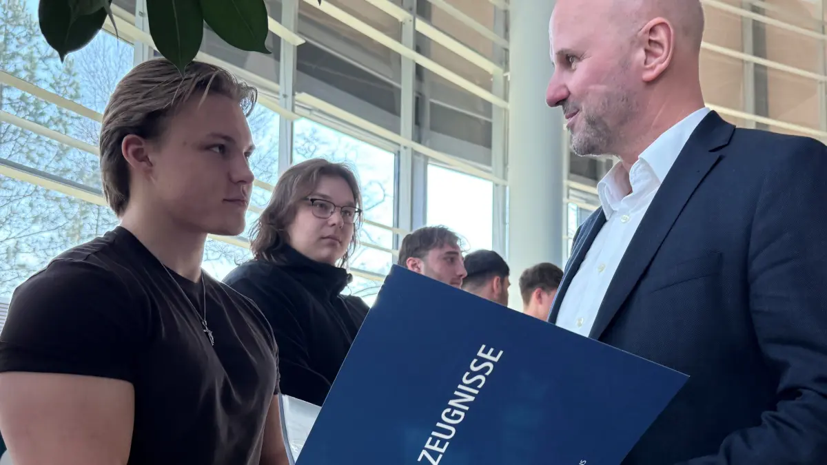 Leag-Arbeitsdirektor Jörg Waniek (r.) überreicht den Ex-Azubis und nun Jungfacharbeitern, hier frischgebackenen Elektronikern, die Zeugnisse.