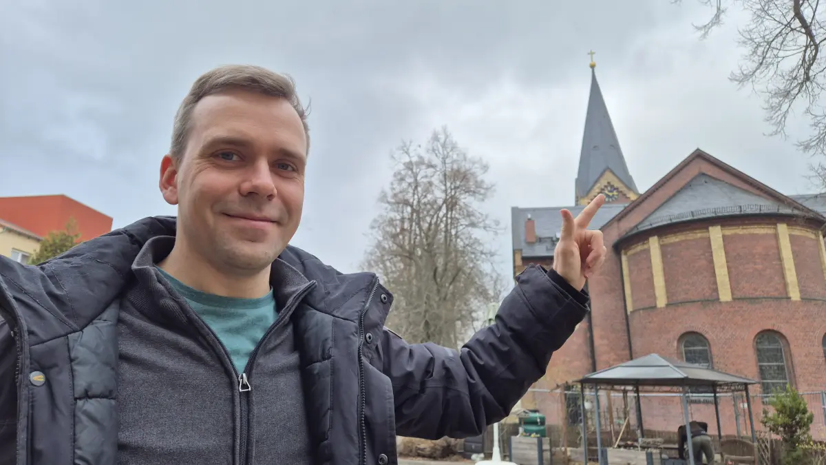 Für den Fotografen tut Lars Städter, Pfarrer der Evangelischen Kirchengemeinde Weißwasser, so, als ob er den Zeiger seiner Kirchenuhr umstellen muss. Muss er aber nicht, auch das geschieht automatisch.