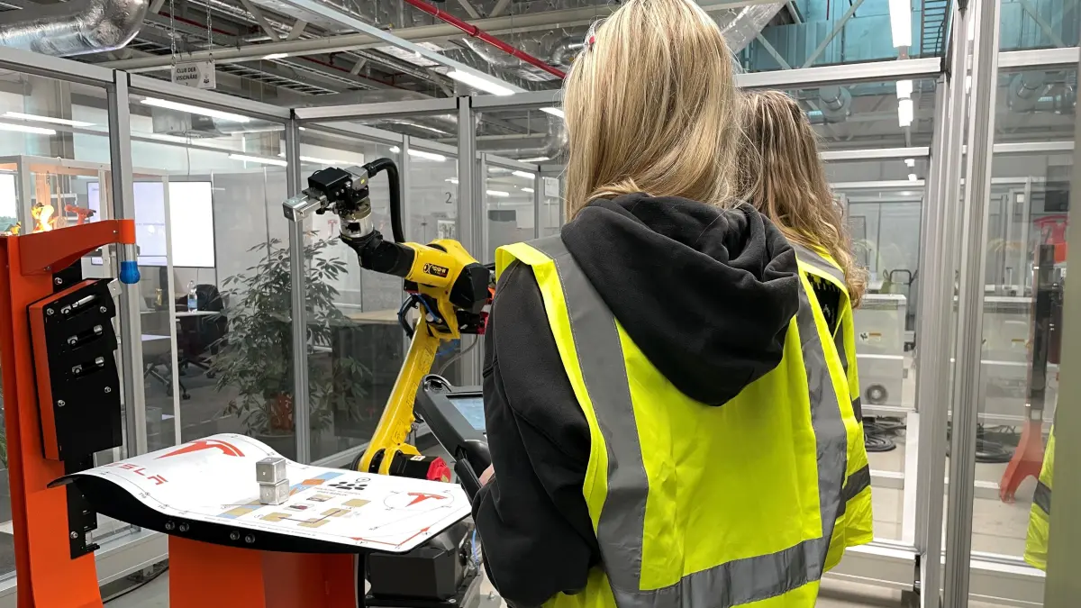 Schülerinnen bei Tesla probieren beim Open Day einen Roboter aus.
