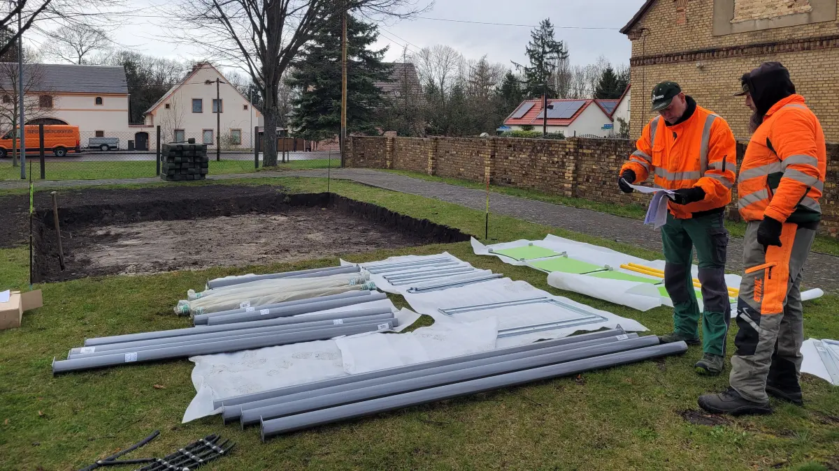 Mitarbeiter des Bauhofs Lauchhammer bereiten die Montage neuer Spielgeräte auf dem Spielplatz in Kostebrau vor.