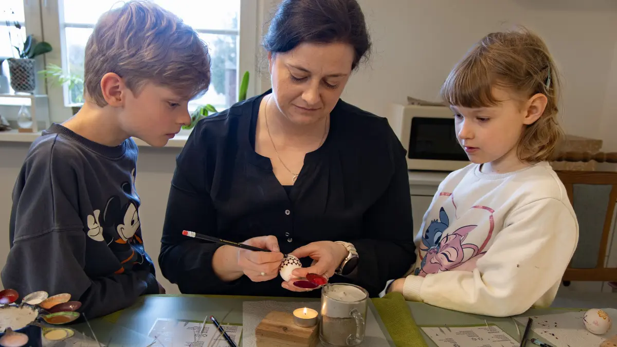 Susann Köbernick mit Charlotte Kremer und Lias Köbernick. Susann Köbernick aus Lübben-Hartmannsdorf verziert Ostereier nach sorbisch-wendischem Brauch.