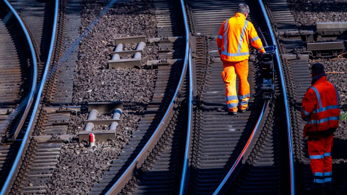 Bauarbeiten bei der Deutschen Bahn: ARCHIV - 09.04.2025, Mecklenburg-Vorpommern, Schwerin: Bauarbeiter vermessen eine Schiene auf der Bahnstrecke Ludwigslust - Wismar kurz vor dem Hauptbahnhof. Die Deutsche Bahn (DB) will 2025 mehr als 490 Millionen Euro in Mecklenburg-Vorpommern investieren. (zu dpa: «Bauarbeiten: Lahntalbahn bleibt sechs Wochen dicht») Foto: Jens Büttner/dpa +++ dpa-Bildfunk +++