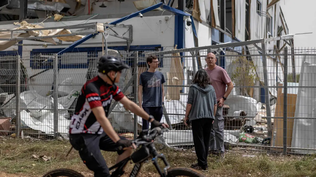 People look at the damage at a factory that got hit by a missile in Petah Tikva, east of Tel Aviv, on April 3, 2026. Israel said it was under attack from a new barrage of Iranian missiles, as US President Donald Trump warned Washington had yet to begin "destroying what's left" of Iran's infrastructure. The war started more than a month ago with US-Israeli strikes on Iran, triggering retaliation that spread the conflict throughout the Middle East, convulsing the global economy and impacting millions of people worldwide. (Photo by Ilia YEFIMOVICH / AFP) /
