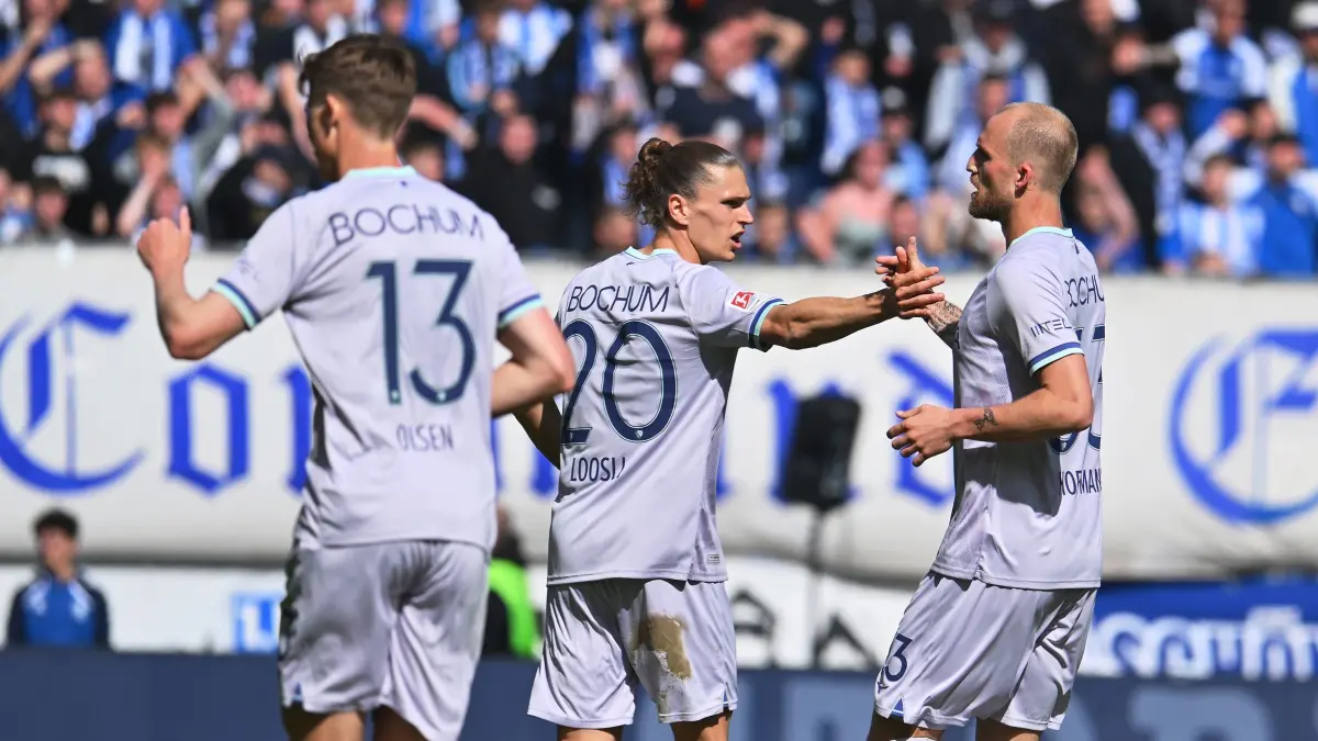 1. FC Magdeburg - VfL Bochum: 04.04.2026, Sachsen-Anhalt, Magdeburg: Fußball, Männer: 2. Bundesliga, 1. FC Magdeburg - VfL Bochum, 28. Spieltag, Avnet Arena: Philipp Hofmann (r) und Noah Loosli (beide VfL Bochum) feiern mit Moritz Kwarteng (l, VfL Bochum) das 2:1. Foto: Swen Pförtner/dpa - WICHTIGER HINWEIS: Gemäß den Vorgaben der DFL Deutsche Fußball Liga bzw. des DFB Deutscher Fußball-Bund ist es untersagt, in dem Stadion und/oder vom Spiel angefertigte Fotoaufnahmen in Form von Sequenzbildern und/oder videoähnlichen Fotostrecken zu verwerten bzw. verwerten zu lassen. +++ dpa-Bildfunk +++