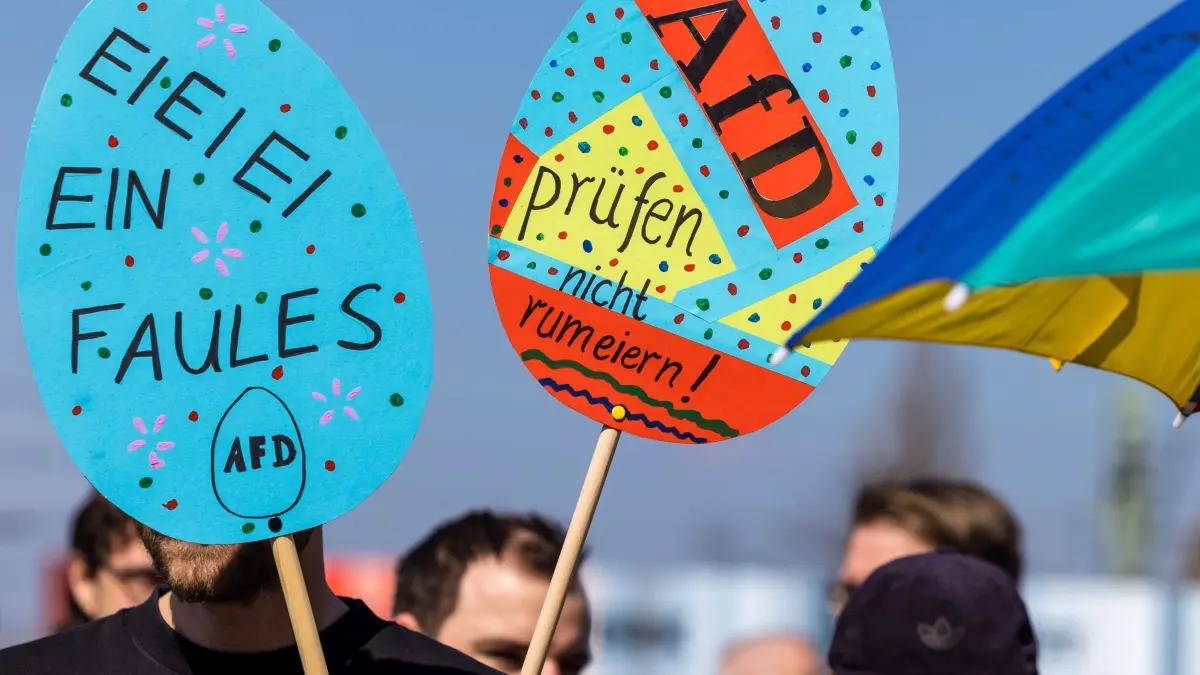 Fortsetzung AfD-Fraktionsklausur - Demo in Cottbus: 11.04.2026, Brandenburg, Cottbus: «AfD prüfen nicht rumeiern» steht auf einem Schild, welches ein Mann bei einer Demonstration am Hauptbahnhof mit sich trägt. Die Demonstration fordert die Überprüfung und das Verbot der AfD, deren Bundestagsfraktion gestern für eine dreitägige Klausurtagung in der Stadt zusammengekommen ist. Foto: Frank Hammerschmidt/dpa +++ dpa-Bildfunk +++