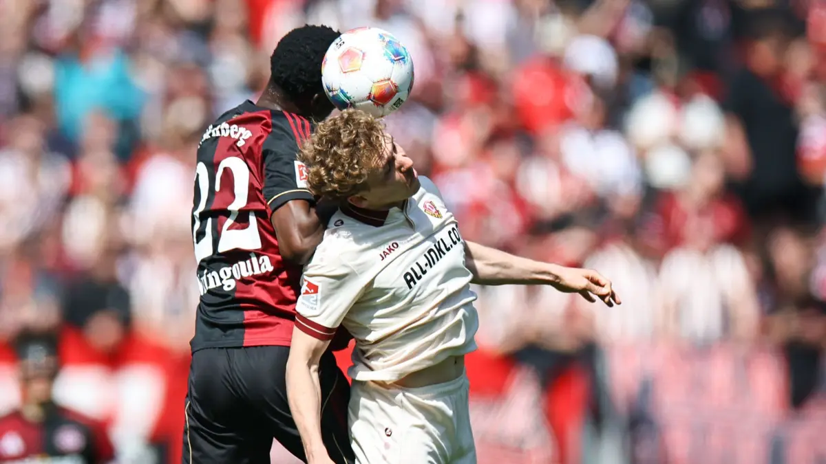 1. FC Nürnberg - Dynamo Dresden: 11.04.2026, Bayern, Nürnberg: Fußball, Männer: 2. Bundesliga, 1. FC Nürnberg - Dynamo Dresden, 29. Spieltag im Max-Morlock-Stadion. Rabby Nzingoula (l, 1. FC Nürnberg) und Luca Herrmann (Dynamo Dresden) kämpfen um den Ball. Foto: Daniel Karmann/dpa - WICHTIGER HINWEIS: Gemäß den Vorgaben der DFL Deutsche Fußball Liga bzw. des DFB Deutscher Fußball-Bund ist es untersagt, in dem Stadion und/oder vom Spiel angefertigte Fotoaufnahmen in Form von Sequenzbildern und/oder videoähnlichen Fotostrecken zu verwerten bzw. verwerten zu lassen. +++ dpa-Bildfunk +++