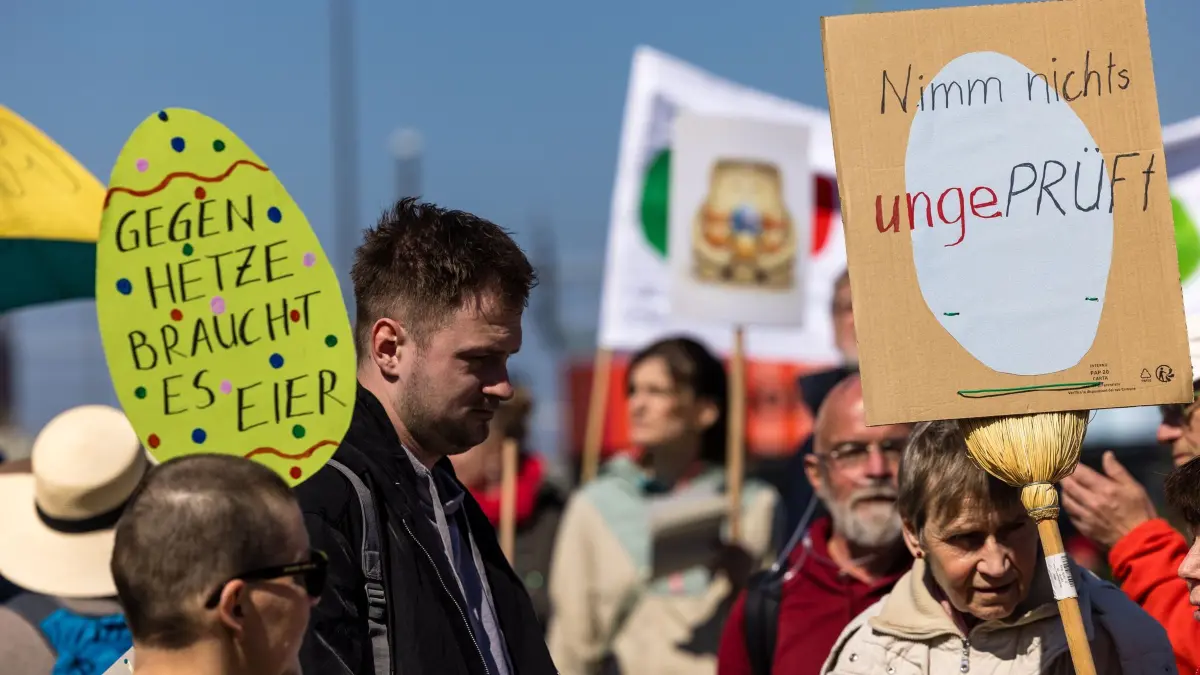 Fortsetzung AfD-Fraktionsklausur - Demo in Cottbus: 11.04.2026, Brandenburg, Cottbus: «Gegen Hetze braucht es Eier» und «Nimm nichts ungeprüft» steht auf Schildern, welche Menschen bei einer Demonstration am Hauptbahnhof mit sich tragen. Die Demonstration fordert die Überprüfung und das Verbot der AfD, deren Bundestagsfraktion gestern für eine dreitägige Klausurtagung in der Stadt zusammengekommen ist. Foto: Frank Hammerschmidt/dpa +++ dpa-Bildfunk +++