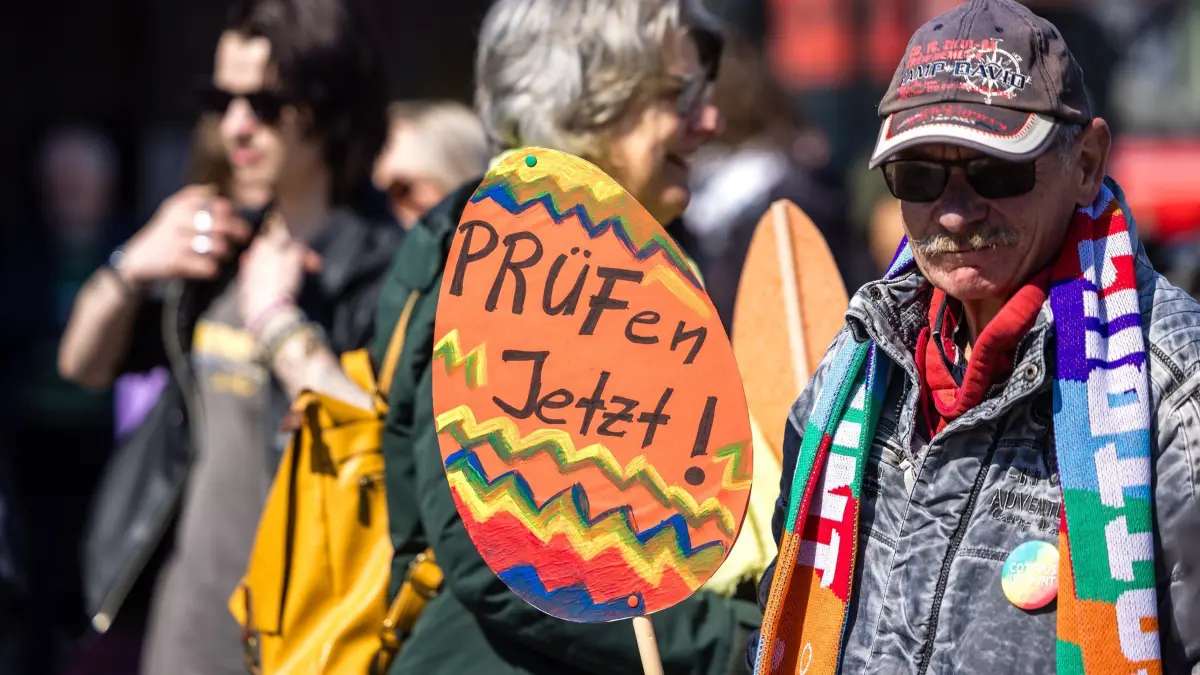 Fortsetzung AfD-Fraktionsklausur - Demo in Cottbus: 11.04.2026, Brandenburg, Cottbus: «Prüfen jetzt» steht auf einem Ei aus Pappe, welches ein Mann bei einer Demonstration am Hauptbahnhof mit sich trägt. Die Demonstration fordert die Überprüfung und das Verbot der AfD, deren Bundestagsfraktion gestern für eine dreitägige Klausurtagung in der Stadt zusammengekommen ist. Foto: Frank Hammerschmidt/dpa +++ dpa-Bildfunk +++