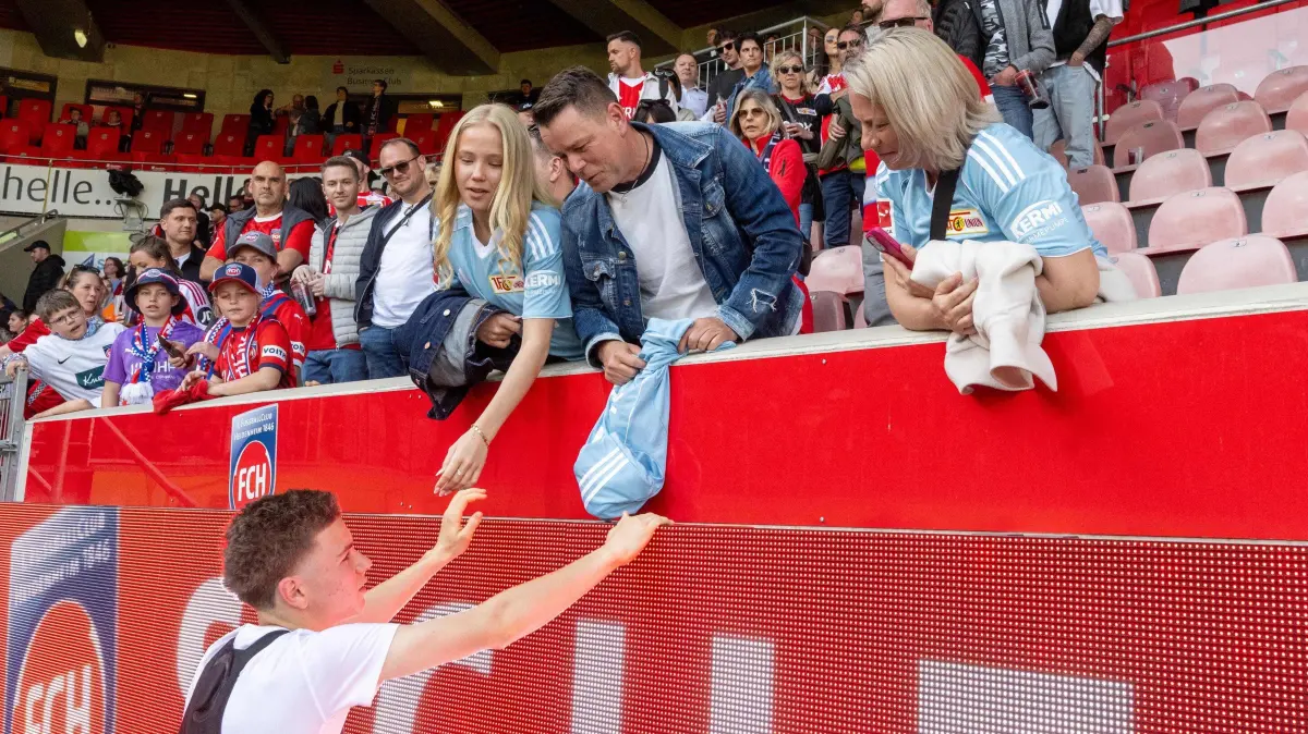 1. BL 1. FC Heidenheim - 1. FC Union 2025/26: Fußball, Herren, 1. Bundesliga, Saison 2025/2026, (29. Spieltag), 1. FC Heidenheim 1846 - 1. FC Union Berlin (3:1), unten Linus Güther (1. FC Union), oben v. l. Helene (Freundin von Linus Güther / 1. FC Union), Kai Noack (Vater von Linus Güther / 1. FC Union), Carola Güther (Mutter von Linus Güther / 1. FC Union), Eltern leben getrennt, Vater hat Trikot von Linus Güther, 11.04. 2026, Foto: Matthias Koch