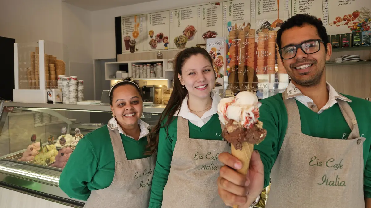 Das neue Team vom "Eis Café Italia" in Senftenberg (Bahnhofstraße): Fernanda Ribeiro Jaques, Juana Pires Dos Santos Lopes und Gustavo Torassi (v. l. n. r.) präsentieren die aktuellen Trends Dubai-Schokolade und Yogurette.