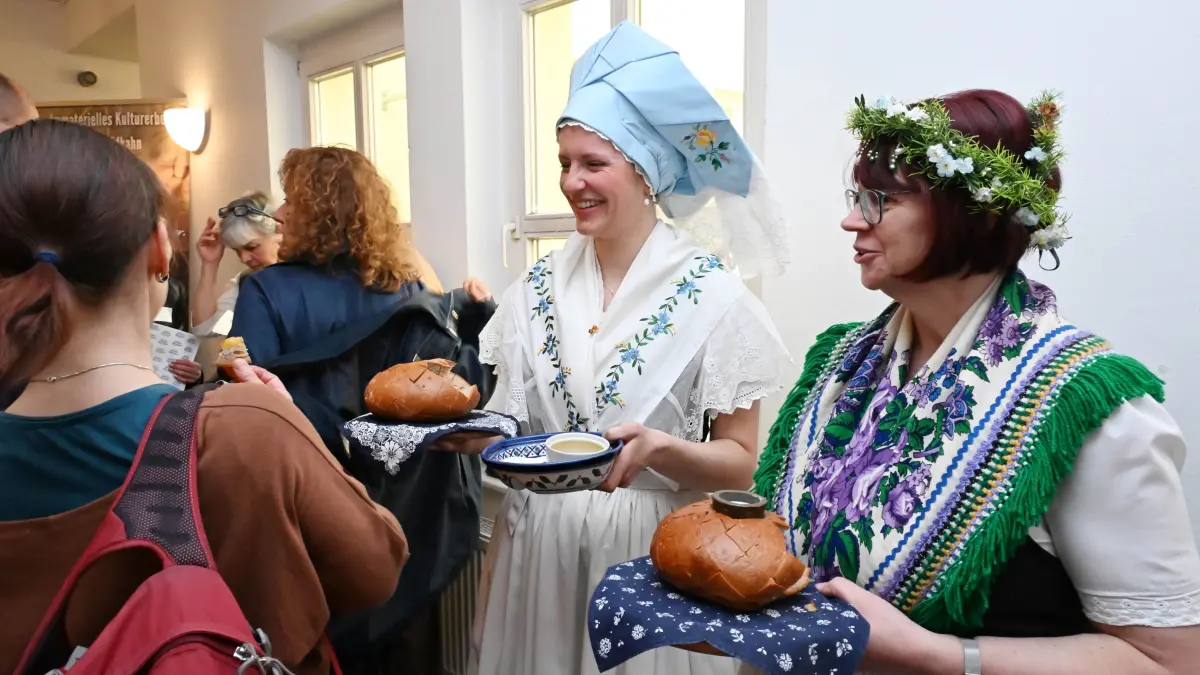 Bei der Regionalkonferenz der deutschen Unesco-Kommission in Cottbus begrüßen Charlott Schüller-Rex aus Jänschwalde (l) und Diana Matiza aus Schleife die Gäste traditionell mit Brot und Salz.