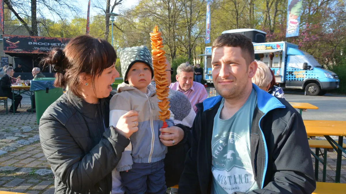 Kostprobe aus der Straßenküche in Spremberg: Dem kleinen Emil schmeckt die frische Spiralkartoffel. Anne-Katrin Völke (l.) und Marcus Hein dürfen natürlich auch probieren.