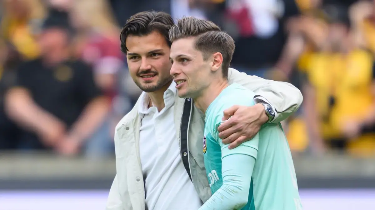 SG Dynamo Dresden - VfL Bochum: 18.04.2026, Sachsen, Dresden: Fußball, Männer: 2. Bundesliga, SG Dynamo Dresden - VfL Bochum, 30. Spieltag, Rudolf-Harbig-Stadion, Torwart Tim Schreiber (Dynamo Dresden, l) und Torwart Daniel Mesenhöler (Dynamo Dresden) umarmen sich nach dem Sieg. Foto: Robert Michael/dpa - WICHTIGER HINWEIS: Gemäß den Vorgaben der DFL Deutsche Fußball Liga bzw. des DFB Deutscher Fußball-Bund ist es untersagt, in dem Stadion und/oder vom Spiel angefertigte Fotoaufnahmen in Form von Sequenzbildern und/oder videoähnlichen Fotostrecken zu verwerten bzw. verwerten zu lassen. +++ dpa-Bildfunk +++