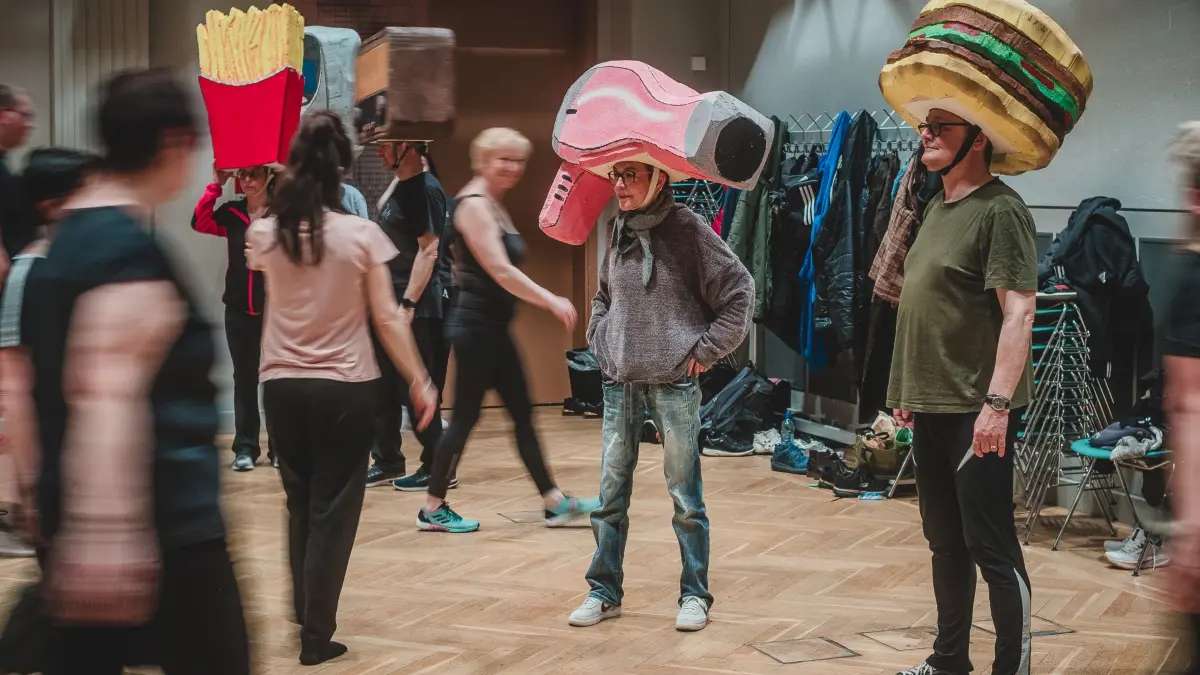 Pommes, Föhn oder Burger auf dem Kopf? Was nach skurrilem Fasching aussieht, ist Teil der großen Schicksalsfrage: Für das Tanzprojekt „Eine Stadt tanzt – die Entscheidung“ proben die Bürger bereits mit ihren aufwendigen Requisiten. Doch welche Rolle spielen diese Symbole des Alltags für die Zukunft von Hoyerswerda?