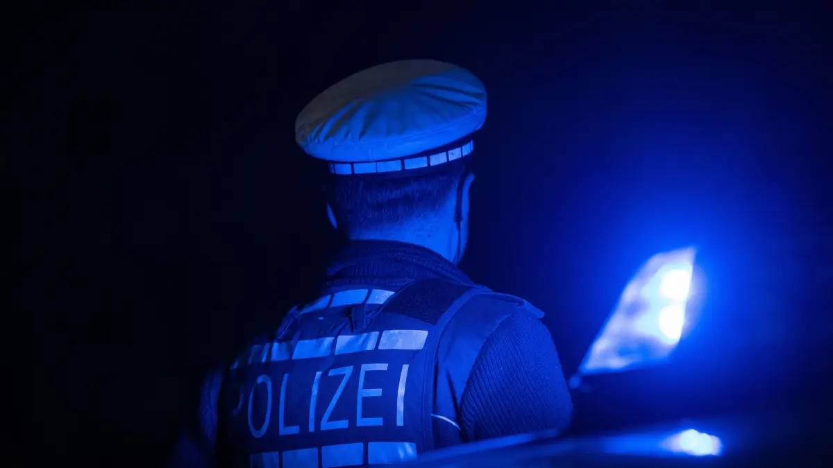 Ein Polizist steht steht nachts neben einem Blaulicht. Warum die Diebe eine Streife angehalten haben ist unklar.