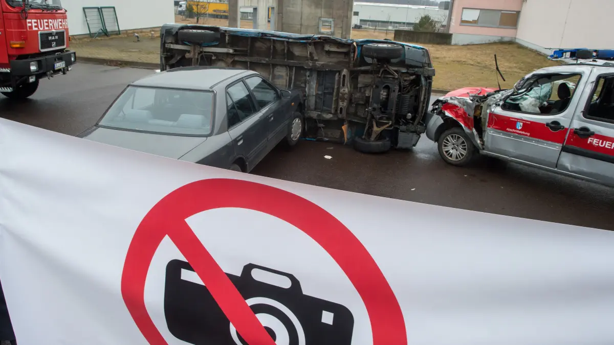 Eine Sichtschutzplane mit dem Piktogramm «Fotografieren verboten» spannt auf einem Übungsgelände der Feuerwehrtechnischen Zentrale des Landkreises Jerichower Land vor einem simuliertem Unfallort. (zu dpa «Gaffer an Unfallstellen») +++ dpa-Bildfunk +++