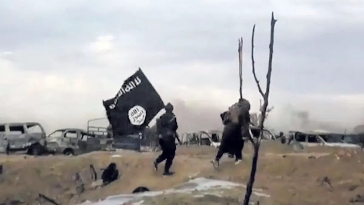 IS Propaganda: ARCHIV - 19.03.2019, Syrien, Baghus: IS-Kämpfer laufen mit einer IS-Flagge. (Screenshot aus einem Video der Amaq News Agency, dem Medienarm des Islamischen Staates - Beste verfügbare Qualität; Illustration zu "14-jähriger Kölner unter Terrorverdacht") Foto: Amaq News Agency/AP/dpa +++ dpa-Bildfunk +++