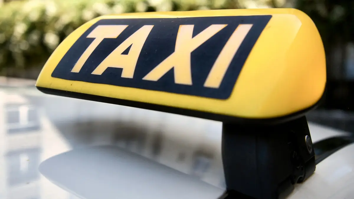 Taxi - Symbolbild: ARCHIV - 01.07.2025, Berlin: Blick auf ein Taxi-Dachzeichen. (zu dpa: «Attacke auf Taxi-Fahrer - 62-Jähriger schwer verletzt») Foto: Paul Zinken/dpa +++ dpa-Bildfunk +++