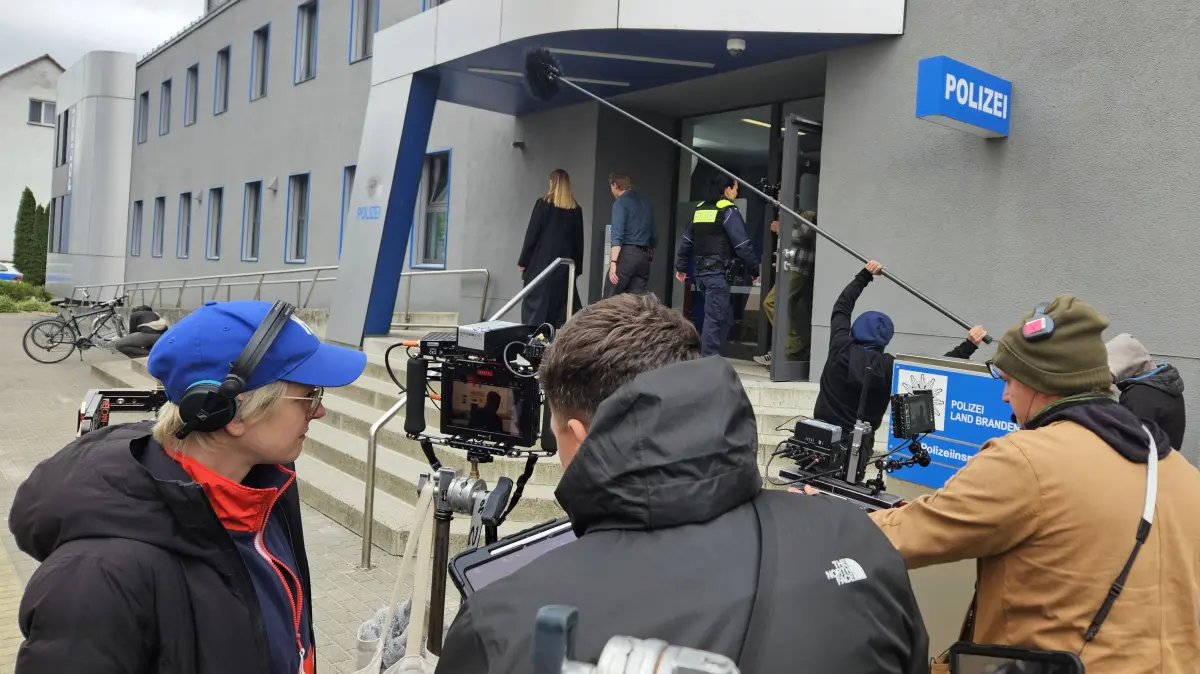 Konzentrierter Blick aufs Detail: Regisseurin Lea Becker (l.) verfolgt eine Szene vor der Senftenberger Polizeiinspektion – das Filmteam arbeitet mit Kamera und Tonangel im laufenden Dreh.