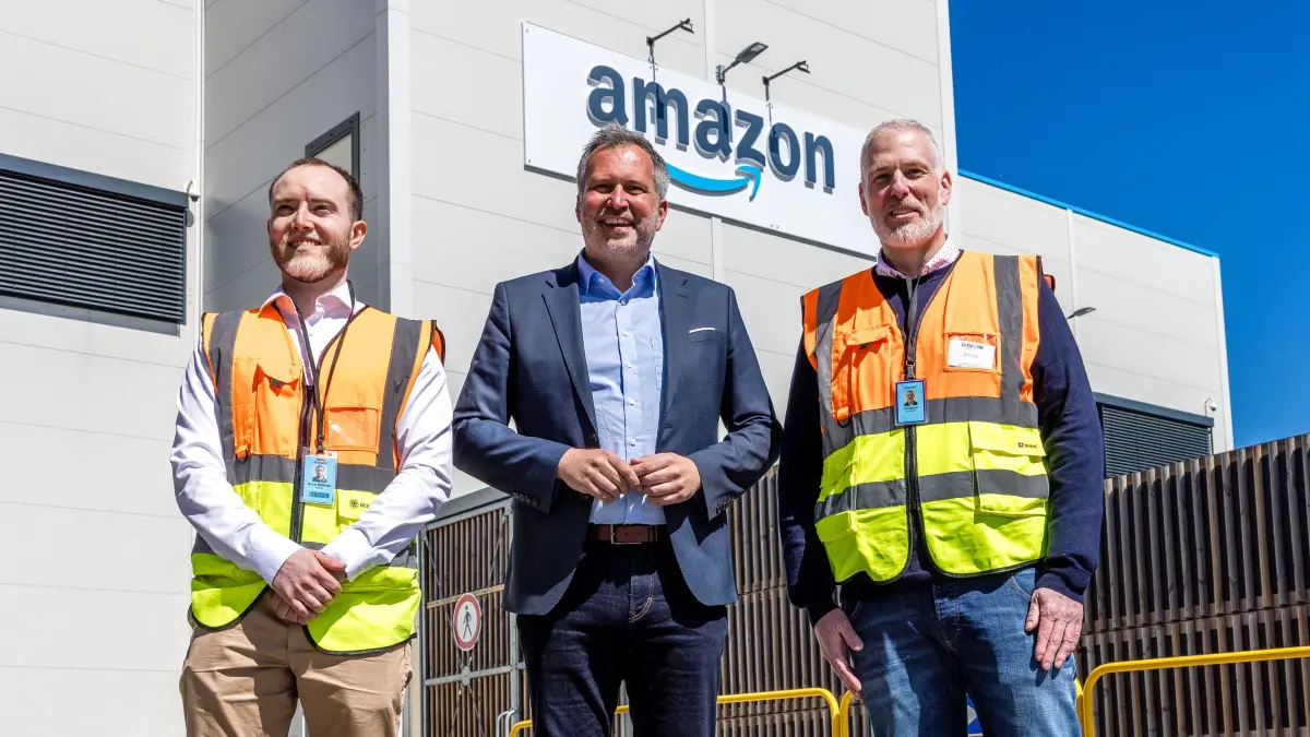 Aron Wolke (zukünftiger Betriebsleiter, l-r), Tobias Schick (SPD), Oberbürgermeister der Stadt Cottbus, und Christian Dülfer, Amazon Logistics Regionalleiter, stehen bei einem Pressetermin vor einem neuen Amazon-Verteilzentrum. Amazon baut sein Logistiknetz in Brandenburg aus: In Cottbus und Dahlewitz an der Berliner Stadtgrenze eröffnet der Online-Versandhändler zwei neue Verteilzentren. Dort werden die ankommenden Pakete entladen, sortiert und für die Auslieferung an die Kunden auf Zustellfahrzeuge verteilt.