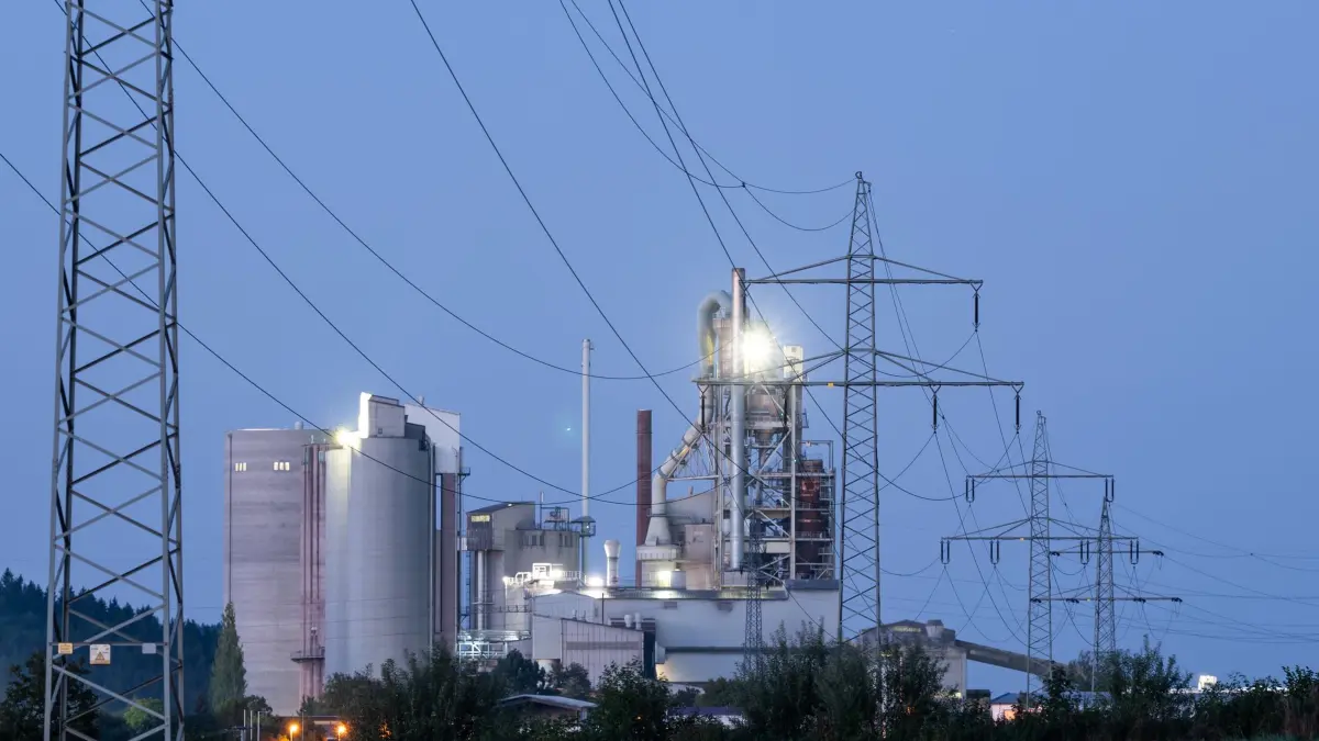 Industrie: ARCHIV - 06.09.2023, Baden-Württemberg, Rottweil: Strommasten stehen im Morgenlicht vor einem Zementwerk. (zu dpa: «EU erlaubt mehr Staatshilfen für Industrie und Landwirte») Foto: Silas Stein/dpa +++ dpa-Bildfunk +++