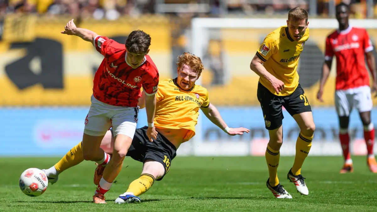 SG Dynamo Dresden - 1. FC Kaiserslautern: 02.05.2026, Sachsen, Dresden: Fußball, Männer: 2. Bundesliga, SG Dynamo Dresden - 1. FC Kaiserslautern, 32. Spieltag, Rudolf-Harbig-Stadion, Robert Wagner (Dynamo Dresden, 2.v.l.) und Niklas Hauptmann (Dynamo Dresden, r) gegen Leon Robinson (1. FC Kaiserslautern). Foto: Robert Michael/dpa - WICHTIGER HINWEIS: Gemäß den Vorgaben der DFL Deutsche Fußball Liga bzw. des DFB Deutscher Fußball-Bund ist es untersagt, in dem Stadion und/oder vom Spiel angefertigte Fotoaufnahmen in Form von Sequenzbildern und/oder videoähnlichen Fotostrecken zu verwerten bzw. verwerten zu lassen. +++ dpa-Bildfunk +++